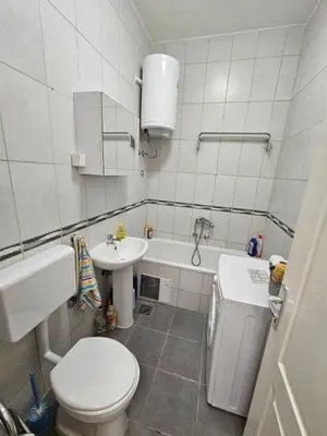 a white bathroom with a toilet and a sink at Stan na dan G & V in Prijedor