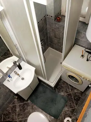 a bathroom with a sink and a shower and a toilet at Dnevna Soba in Doboj