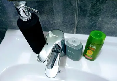 a sink with a faucet and other bathroom items on it at Dnevna Soba in Doboj