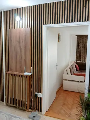 a living room with a striped wall with a couch at Dnevna Soba in Doboj