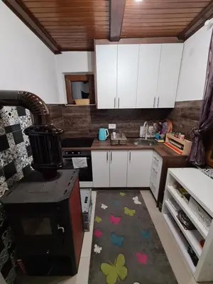 a kitchen with white cabinets and a rug on the floor at Vikendica sa djakuzijem Borik in Grabova Kosa
