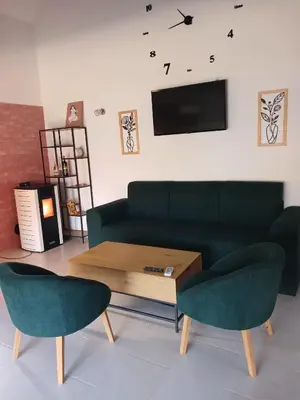 a living room with a green couch and two chairs at Una, Home on river bank in Spilja