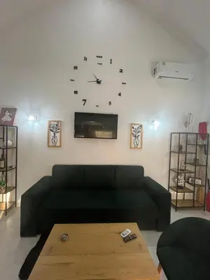 a living room with a couch and a clock on the wall at Una, Home on river bank in Spilja