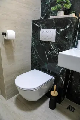 a bathroom with a white toilet and a sink at Fancy new 2bdrm ap free garage in Banja Luka