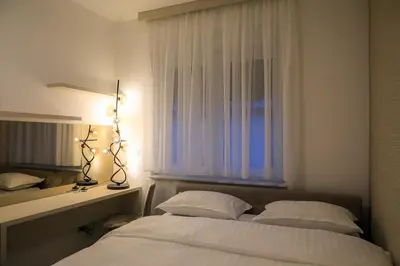a bedroom with two beds and a window with lights at Fancy new 2bdrm ap free garage in Banja Luka