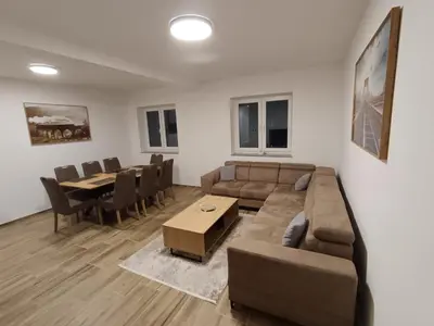 a living room with a couch and a table at White Queen Apartments 1 in Sanski most