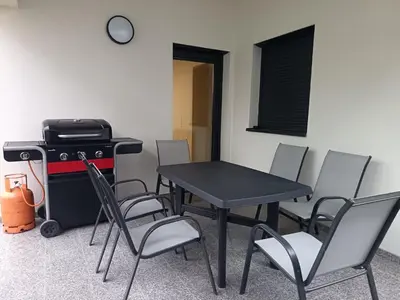 a table and chairs in a room with a stove at White Queen Apartments 1 in Sanski most
