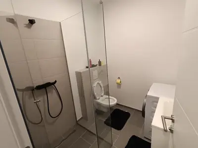 a small bathroom with a shower and a toilet at White Queen Apartments 1 in Sanski most