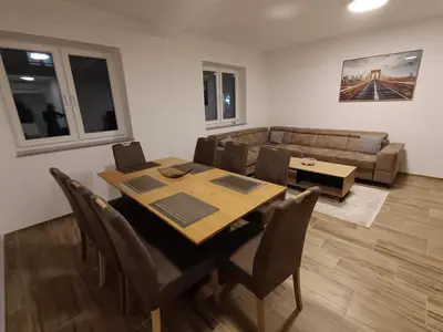a dining room with a table and a couch at White Queen Apartments 1 in Sanski most