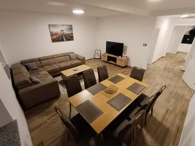 a living room with a table and a couch at White Queen Apartments 1 in Sanski most