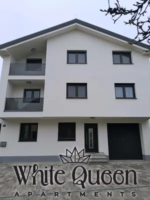 a white queen apartment building with a sign in front of it at White Queen Apartments 1 in Sanski most