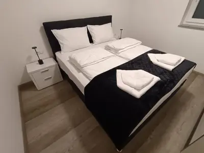 a large bed with two white towels on it at White Queen Apartments 1 in Sanski most