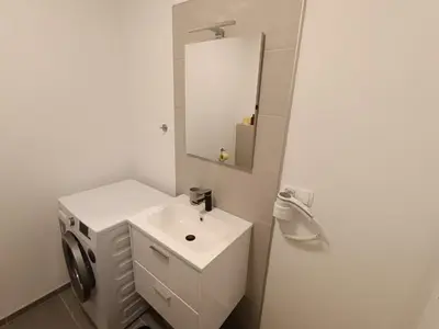 a white bathroom with a sink and a mirror at White Queen Apartments 1 in Sanski most