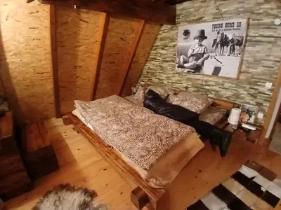 a room with a couch and a stone wall at Forest house ALEKSANDAR in Srbac