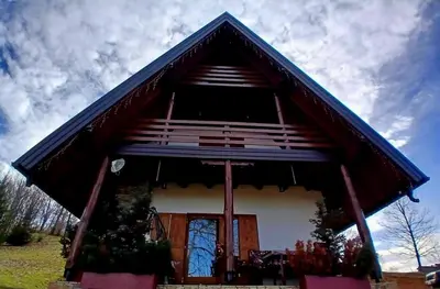 a small house with a blue roof at Forest house ALEKSANDAR in Srbac