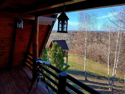 a view from the porch of a cabin with a bell tower at Forest house ALEKSANDAR in Srbac