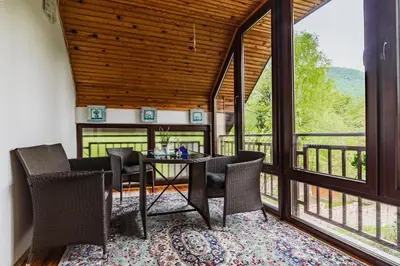 a dining room with a table and chairs and large windows at The Hide Aside in Plješevica