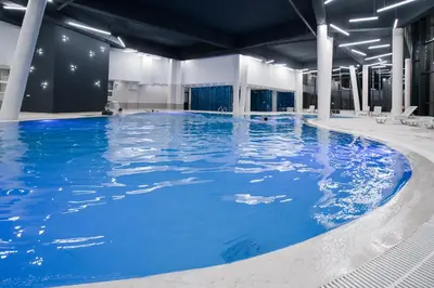 a large pool with blue water in a building at Premium Apartment in Fojnica
