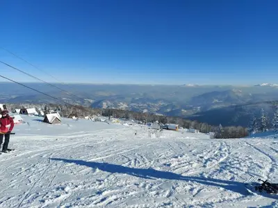a person riding a snowboard down a snow covered slope at Premium Apartment in Fojnica