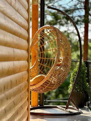 a wicker chair sitting on a table next to a window at Villa Pine in Lukavac
