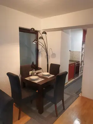 a dining room table with chairs and a lamp at Srce grada Gradiška in Bosanska Gradiška