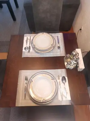 a table with two plates and silverware on it at Srce grada Gradiška in Bosanska Gradiška