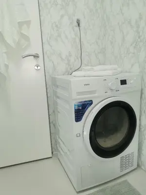 a white washing machine in a room with a door at Srce grada Gradiška in Bosanska Gradiška