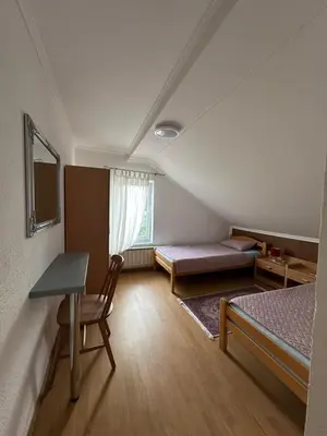 a room with two beds and a table and a desk at White house in Bihać