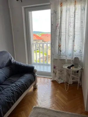 a living room with a couch and a large window at White house in Bihać