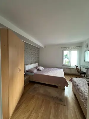 a bedroom with a bed and a desk and a window at White house in Bihać