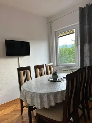 a dining room with a table and chairs and a window at White house in Bihać