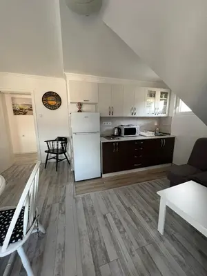 a kitchen and living room with a white refrigerator at White house in Bihać