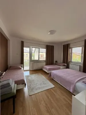 a bedroom with two beds and a large window at White house in Bihać