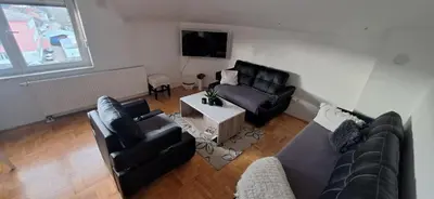 a living room with two couches and a table at Apartments Padrino BP in Bosanski Novi