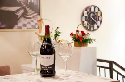 a bottle of wine sitting on a table with two glasses at Apartments Padrino BP in Bosanski Novi