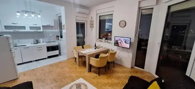 a kitchen and dining room with a table and chairs at Apartments Padrino BP in Bosanski Novi