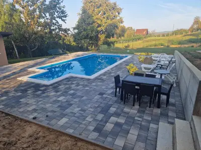 a patio with a table and chairs next to a swimming pool at Vikendica El Paradiso Banjaluka in Laktaši