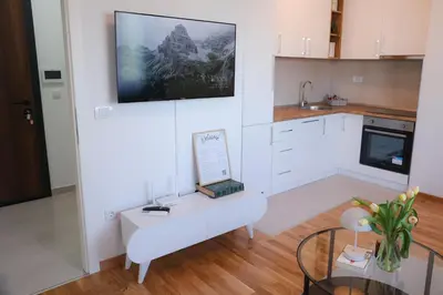 a living room with a white couch and a table at Apartman Mint&White Borik in Banja Luka