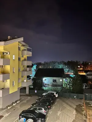 a row of cars parked in a parking lot at night at Apartman Mint&White Borik in Banja Luka