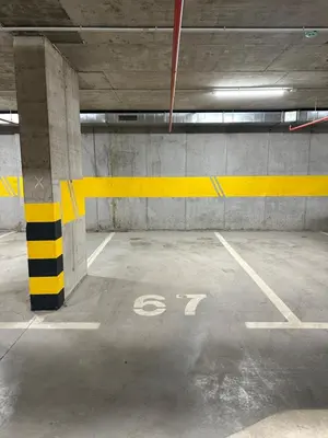 an empty parking garage with a yellow line on the floor at Apartman Mint&White Borik in Banja Luka