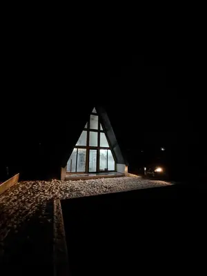 a building at night with a large window at Vikendica sa bazenom HUZUR in Cazin