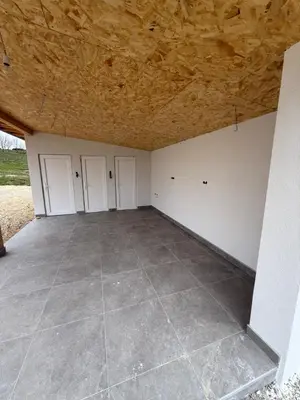 a garage with four doors and a tile floor at Vikendica sa bazenom HUZUR in Cazin