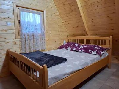a bedroom with a bed in a log cabin at Vikendica Elenda Banja Luka in Laktaši