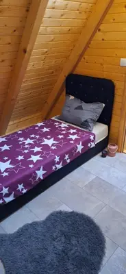 a bed with a purple blanket with stars on it at Vikendica Elenda Banja Luka in Laktaši