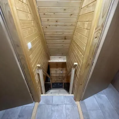 an attic room with a wooden ceiling and a staircase at Vikendica Elenda Banja Luka in Laktaši