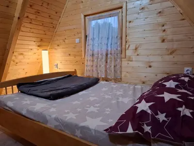 a bed in a log cabin with a window at Vikendica Elenda Banja Luka in Laktaši