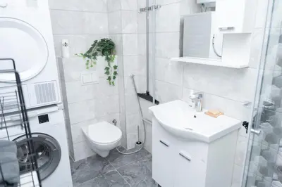 a white bathroom with a toilet and a sink at Apartment Friday in Travnik