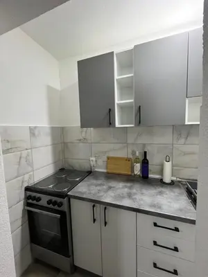 a kitchen with a stove and white cabinets at Apartman Ivana in Banja Luka