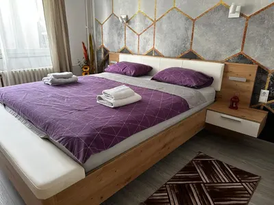 a bedroom with a purple bed with towels on it at Apartment in Doboj - City Center - Cik Cak in Doboj