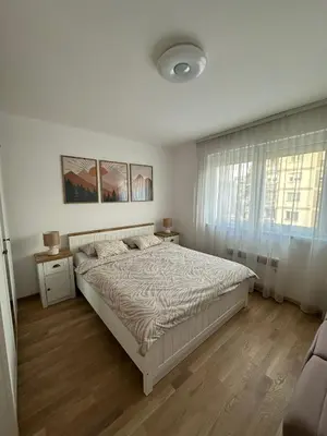 a white bedroom with a bed and a window at City Apartment in Banja Luka